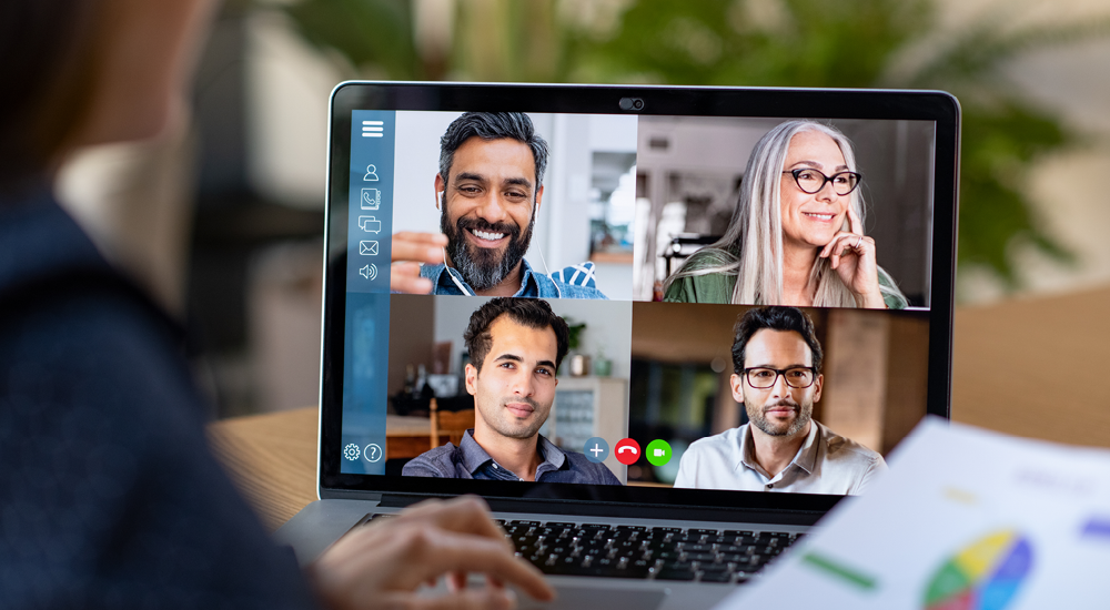 Laptop screen showing a conference call underway with four attendees